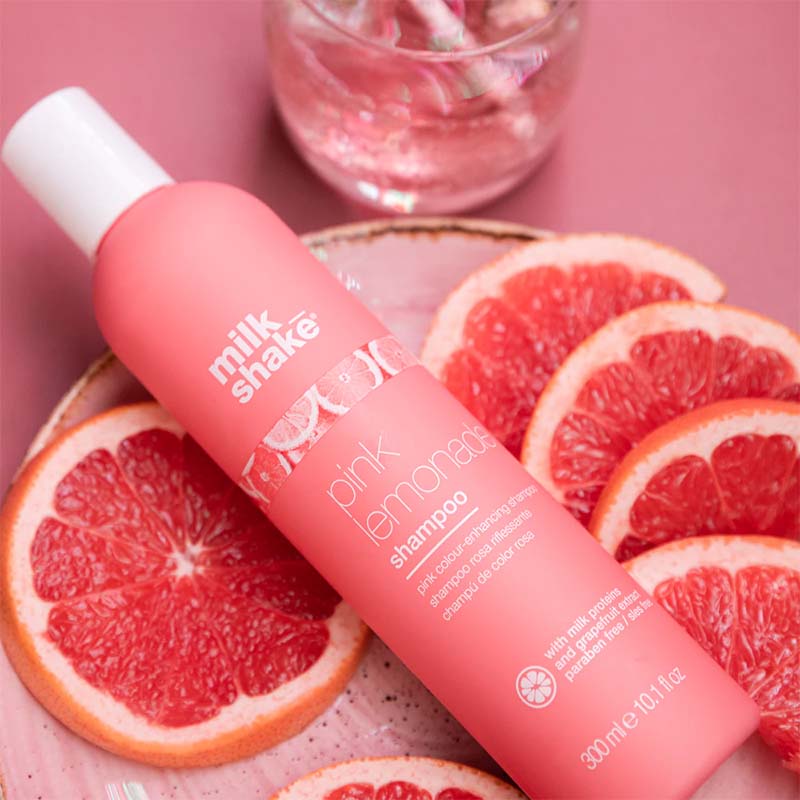 Bottiglia rosa con tappo flip top bianco e rosa. Piccola immagine sul fronte raffigurante varie fette limoni rosa come la bottiglia. La bottiglia risulta appoggiata su un letto di fette di limoni rosa/rossi.